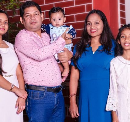 A family of five, including a baby, posing.