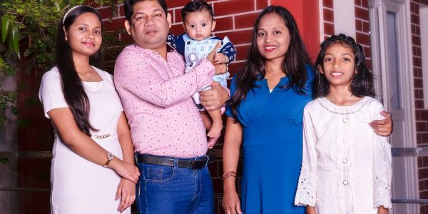 A family of five, including a baby, posing.