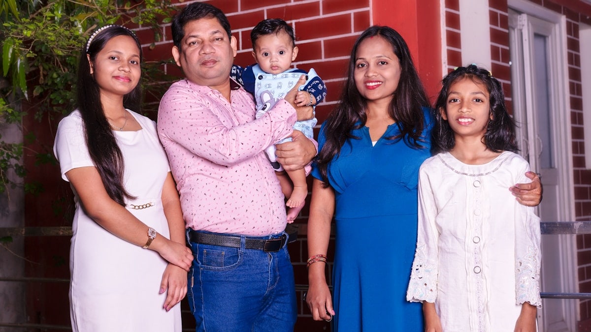 A family of five, including a baby, posing.