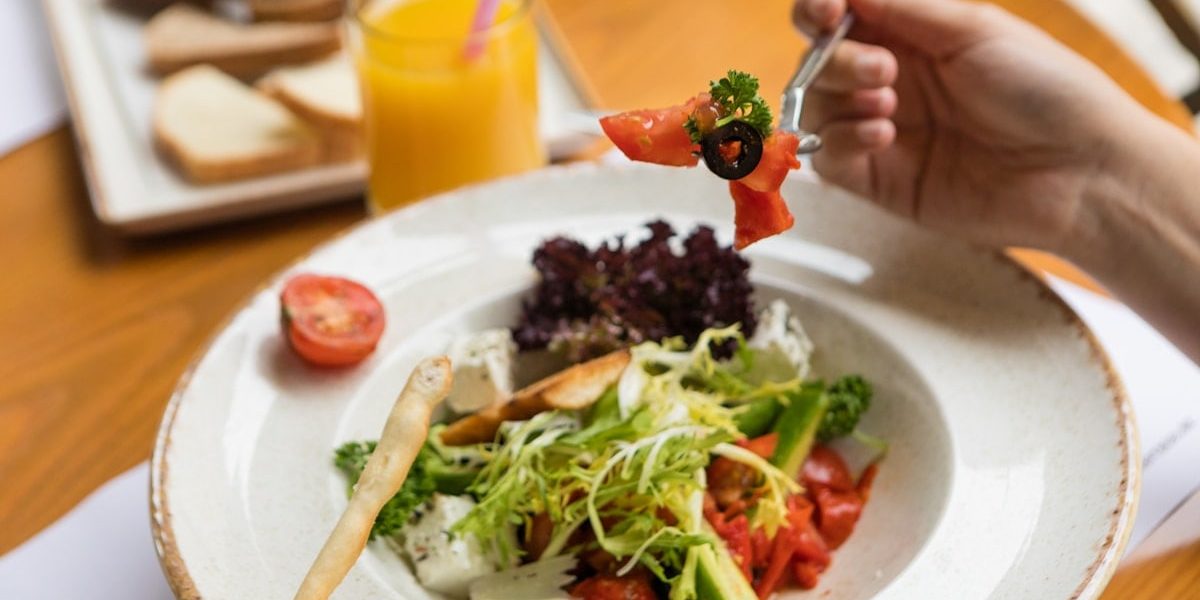 Woman eating beautiful vegetarian salad close up